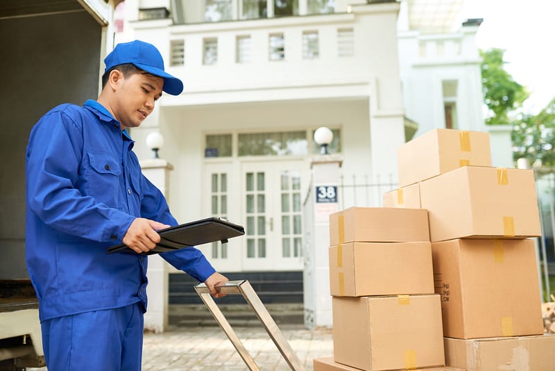 Man pushing trolley with cardboard boxes